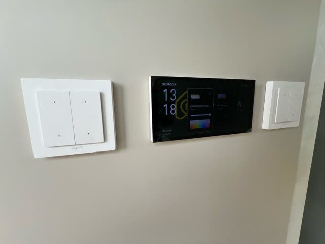 Smart-home control panel and light switches on an interior wall