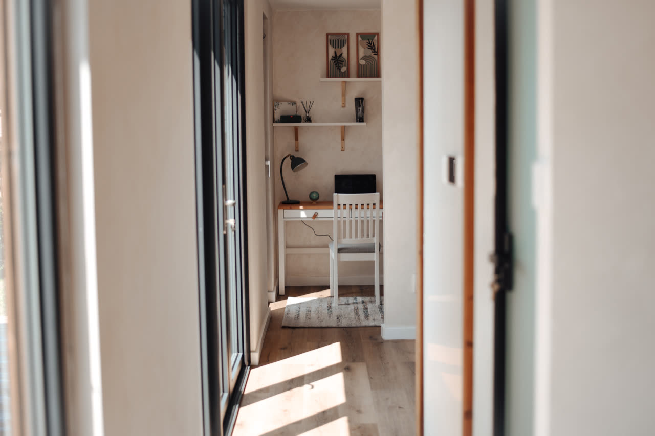 Sunlit hallway leading to a small workspace inside a Moduliva unit
